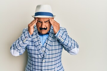 Mature middle east man with mustache wearing vintage and elegant fashion style with hand on head, headache because stress. suffering migraine.