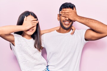 Young father and daughter wearing casual clothes smiling and laughing with hand on face covering eyes for surprise. blind concept.