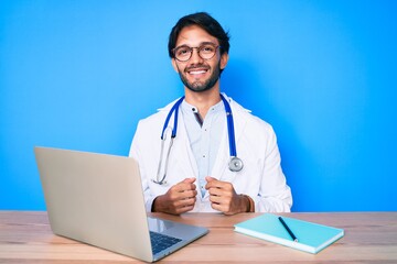 Handsome hispanic man wearing doctor uniform working at the clinic with a happy and cool smile on face. lucky person.