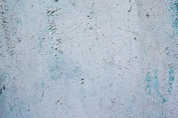 Blue-white background: an old relief wall with cracks and bulges of white-gray color, through which the blue appears