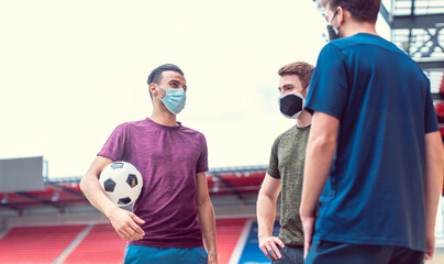 Soccer players in football stadium during covid-19 wearing masks