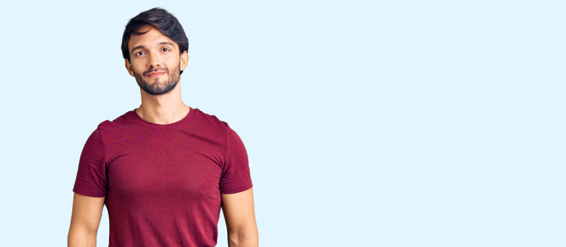 Handsome hispanic man wearing casual clothes relaxed with serious expression on face. simple and natural looking at the camera.