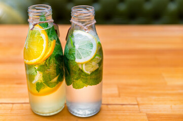 Set of bottles with lemonade or mojito cocktail with lemon and mint