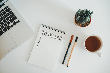 To do list on spiral notepad. office desk with laptop, "to do list" notebooks and plant on white background. Blank notebook, pen, keyboard on with table. Planning notes writing concepts.
