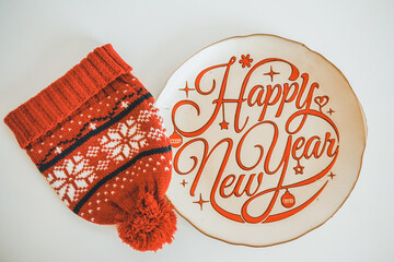 Happy 2021 New Year. Typography Happy New Year handwritten plate with red wool hat. 