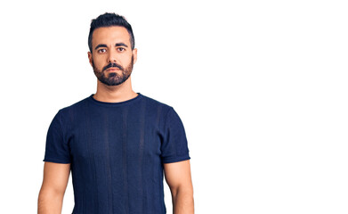 Fototapeta premium Young hispanic man wearing casual clothes with serious expression on face. simple and natural looking at the camera.