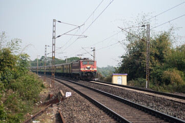 Fototapeta na wymiar Khirai Midnapore, West Bengal, India - 11th October 2020 : a passenger train of Indian Railway accelerating.
