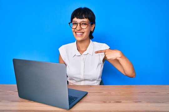 Beautiful brunettte woman working using computer laptop pointing finger to one self smiling happy and proud