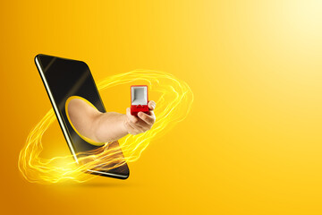 A hand gives a red box with a ring through the smartphone screen on a yellow background. The concept of marriage proposal to olayn, social networks, love, online dating.