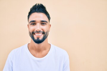 Young arab man smiling happy walking at the city.