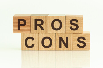 Pros Cons - text on wooden cubes on a white gradient background.