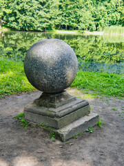 Ancient stone ball in the romantic Arkadia park, Poland