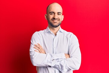 Young handsome bald man wearing elegant shirt happy face smiling with crossed arms looking at the camera. positive person.