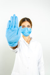 Young doctor woman, medical professional annoyed with bad attitude making stop sign with hand, saying no, expressing security, defense or restriction, maybe pushing  