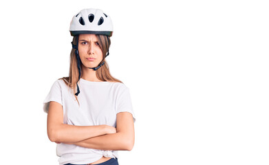 Young beautiful girl wearing bike helmet skeptic and nervous, disapproving expression on face with crossed arms. negative person.