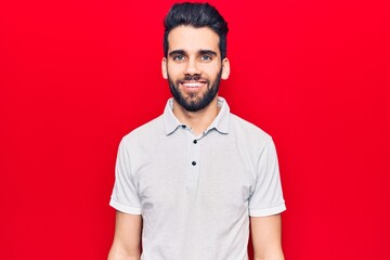 Young handsome man with beard wearing casual polo with a happy and cool smile on face. lucky person.