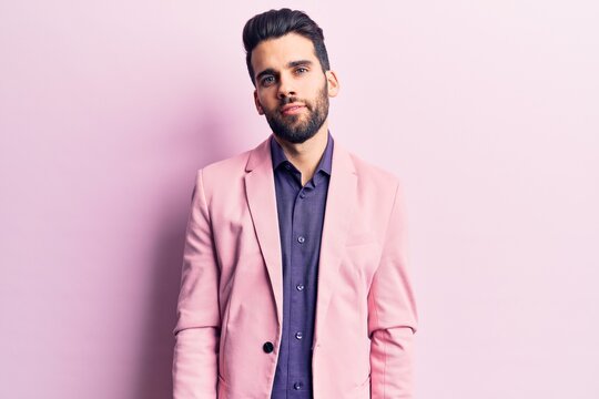 Young handsome man with beard wearing elegant jacket relaxed with serious expression on face. simple and natural looking at the camera.