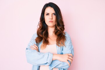 Fototapeta premium Young beautiful brunette woman wearing casual clothes over pink background skeptic and nervous, disapproving expression on face with crossed arms. negative person.