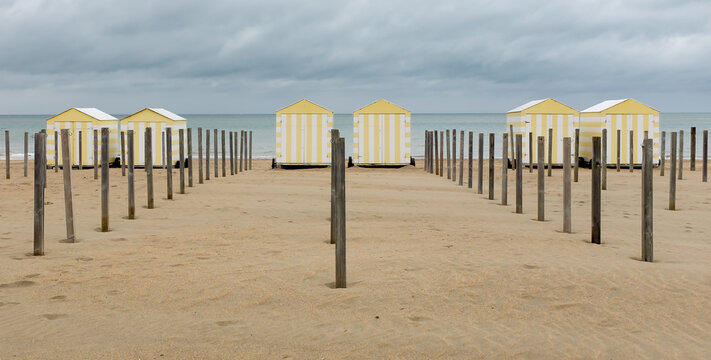Row of colorful striped beach huts.
