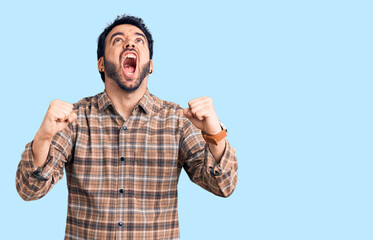Young hispanic man wearing casual clothes angry and mad screaming frustrated and furious, shouting with anger. rage and aggressive concept.