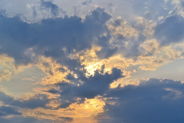 Beautiful sky and sun hidden behind dark clouds at sunset