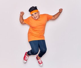 Adorable hispanic kid wearing sportswear smiling happy. Jumping with smile on face over isolated white background