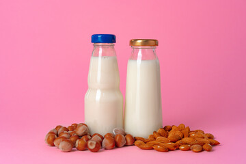 Non-dairy vegan milk made of nuts in glassware against pink background