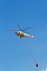 Firefighting helicopter with fire bucket flies