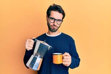 Young hispanic man drinking italian coffee skeptic and nervous, frowning upset because of problem. negative person.