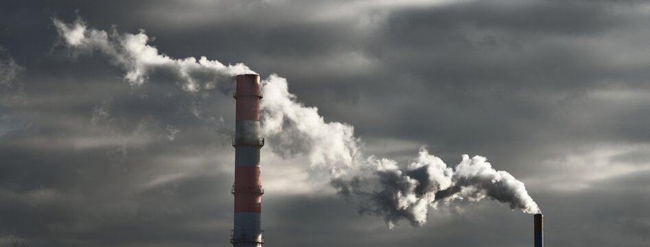 Panoramic view of the large central heating station in dramatic light. Pipe close-up. Ecology, ecological issues, fuel and power generation, environmental damage. Dark industrial cityscape