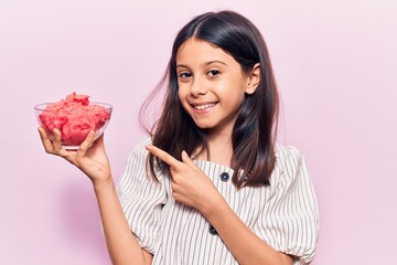 Beautiful child girl holding ice cream smiling happy pointing with hand and finger