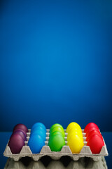 Easter festive multicolor eggs carton, blue background