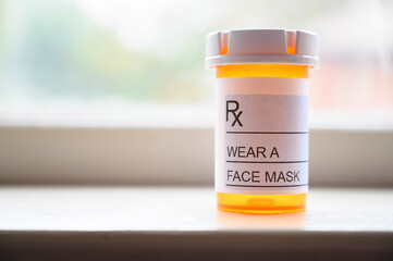 Prescription bottle with label saying WEAR A FACE MASK as a pandemic 