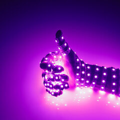 thumbs up hand covered with purple led lights, illuminated background