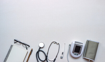 Stethoscope, tonometer, thermometer and doctor's notebook on white background. Concept of first...