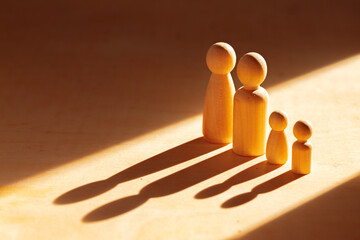 Four wooden puppets in sunlight on wooden table
