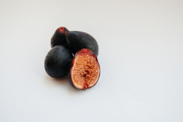 Ripe and sweet figs cut and arranged in a plate on a white background with free space. Fruits and vegetarianism