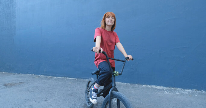 Young woman posing with BMX bicycle outdoor on the street  - Powered by Adobe