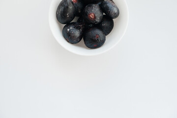 Ripe and sweet figs cut and arranged in a plate on a white background with free space. Fruits and vegetarianism