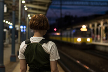 young woman traveler wait train on the station in the night