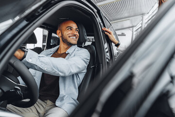 Young attractive woman salesperson in car showroom showing a car to her male client