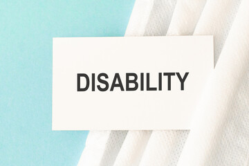 Word disability with medical mask on a blue background.