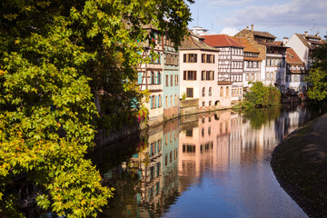 Fototapeta na wymiar Scenic view on a canal and buildings in Strasbourg city, little france, old town district. Street with architecture reflecting in water. Alsace, France