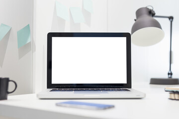 Laptop on a desk and blurred office background.