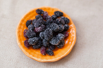 frozen mulberries on orange saucer