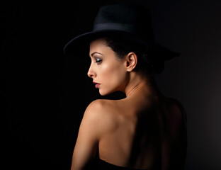 Beautiful makeup woman with elegant healthy neck, nude back and shoulder on black background in fashion hat with empty copy space. Closeup profile view portrait.