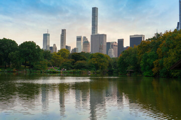 Reflection in lake water of Central Park with a view of trees and skyscrapers in the background