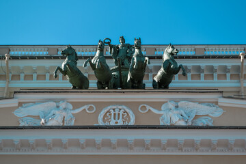 Ostrovsky Square, Saint Petersburg, Russia, 11.10.2020. Ancient green sculpture of cavalry with horses stands on facade of yellow building of Russian State Drama Theater named A.S. Pushkin.