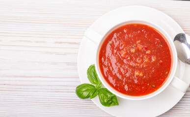 Gazpacho in a white plate and basil