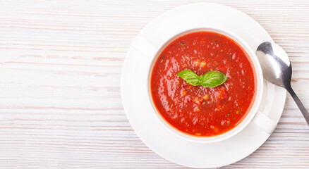 Gazpacho in a white plate and basil